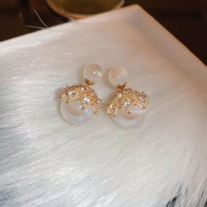 Macro shot of French style pearl earring with gold crown setting and cubic zirconia accents