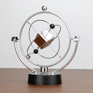 Detail of metal kinetic desk ornament with a wooden cube on a sleek black base