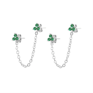 Detailed view of silver chain earrings with emerald green zircon flower studs