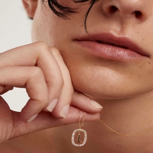Close-up of a 18K gold S925 sterling silver necklace with a crystal letter L pendant
