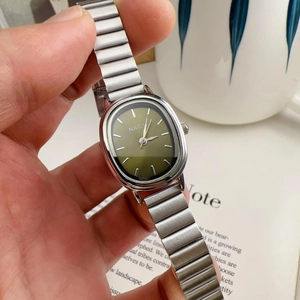 Close-up of elegant women's watch with green oval dial and silver alloy strap