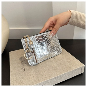 Detail of silver faux snake skin mini coin purse with a gold metal tassel keychain