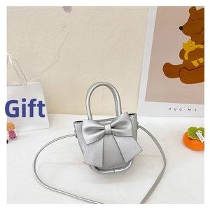 Detail of silver mini crossbody bag with a large bow decoration and matte texture