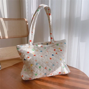 Close-up of quilted cotton tote bag with colorful polka dots and vintage fabric label