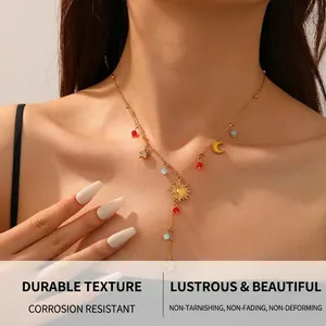 Detail view of gold celestial Y-necklace featuring sun, moon, and star charms with colorful beads