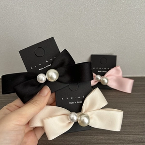 Three-piece set of satin bow hair clips with pearls in black, beige, and pink colors