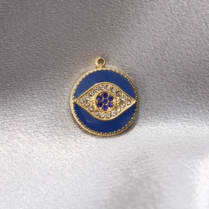 Goldener Evil-Eye-Anhänger mit blauem Emaille und Strasssteinen auf Silverseide