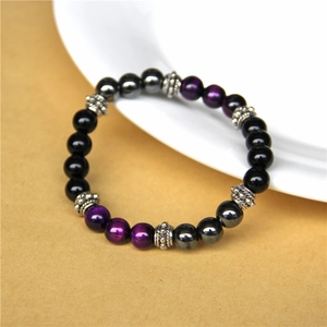 Macro shot of natural purple and black stone beads with textured silver spacer beads