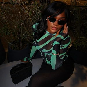 Close-up of green and black zebra print sheer mesh long sleeve top for women