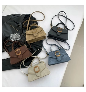 Flat lay of commute handbags in khaki, black, brown, blue, and cream with suede texture