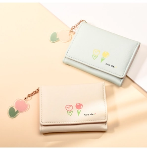 Detail of light green and beige tulip wallets with nice day print and flower charm