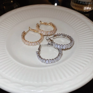 Detailed view of silver and gold hoops with rectangular baguette-cut cubic zirconia