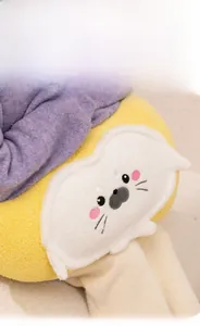 Close-up of yellow and white plush seal pillow with cute embroidered face and soft texture