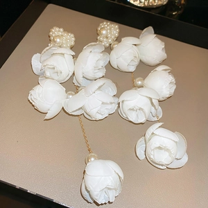 Elegantes pendientes de borla con flores de tela blanca, perlas y cadena dorada.