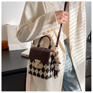 Detail of French style quilted bag with brown PU leather flap and a cute rabbit pendant