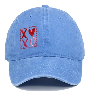Dettaglio del ricamo cuore XOXO sul berretto da baseball vintage in cotone lavato blu