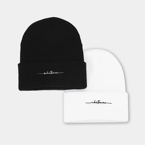 Black and white knit beanies with whatever script embroidery in a minimalist winter style
