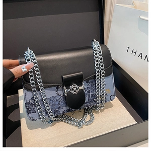 Detail of a chic chain shoulder bag with blue floral print and a silver rose buckle