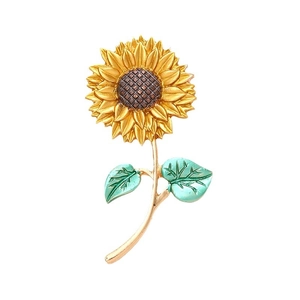 Golden sunflower alloy charm with enamel details and green leaves on white background