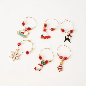 Close-up of 6 Christmas wine glass charms with festive enamel pendants and red beads