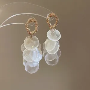 Elegant gold round earrings with white shell tassel sequins and silver needle stud backings