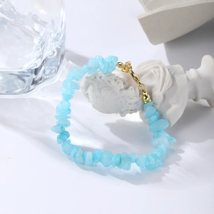 Close-up of light blue natural crushed stone bracelet on a white artistic sculpture stand