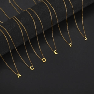 Elegant 18K gold plated stainless steel alphabet pendant necklaces on black display
