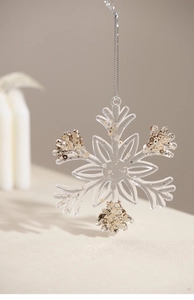 Detailed view of clear acrylic snowflake ornament with sparkling gold and copper glitter