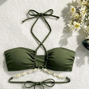 Close-up of olive green ribbed bikini top with shell charms and golden metal rings