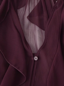 Dettaglio macro del tessuto in chiffon rosso scuro con bordi a balze e pieghe