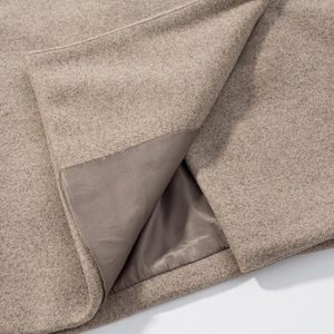 Detail view of the camel wool coat showing the thick fabric and smooth inner lining