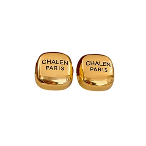 Elegant gold square stud earrings with black letter engraving on a white background