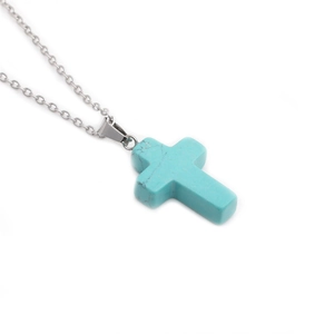 Detail of turquoise stone cross pendant with silver stainless steel chain and metal link