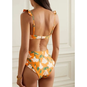Rear view of orange floral high-waisted bikini set with ruffled straps and white lily print