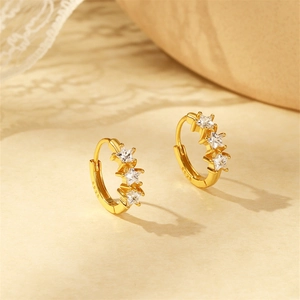 Macro detail of S925 sterling silver stamp on golden star-shaped earrings with zircons
