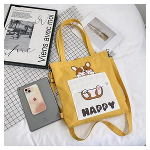 Detail of yellow canvas tote bag with cute corgi illustration and adjustable strap