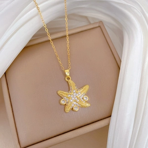 Macro view of gold starfish pendant necklace with crystals on a jewelry box