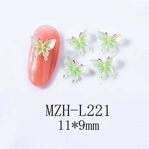 Macro detail of 11x9mm green butterfly resin nail art charm with glitter finish