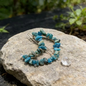 Detailed view of silver crescent moon hair clip with blue-green natural crystal stones