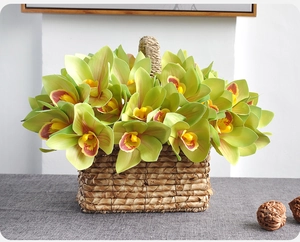 Detailed view of artificial green orchid in a rustic woven basket for home decoration