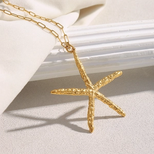 Detail of 18K gold-plated starfish pendant with hammered texture on a cable chain