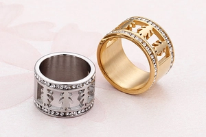 Close-up of hollowed-out girl silhouettes on wide rings with double zircon row detail