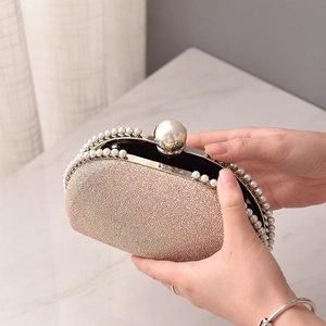 Elegant champagne gold sequin evening clutch bag with pearl trim and clasp closure