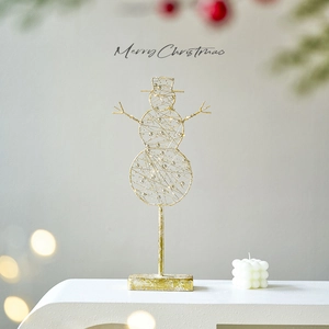 Golden LED snowman Christmas ornament with warm lights on a white display stand