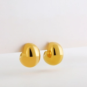 Close-up of hollow 18K gold teardrop earrings with a smooth polished metallic finish