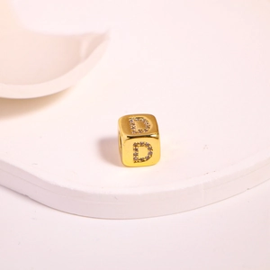 Macro shot of gold cubic bead with rhinestone letter D for DIY jewelry making