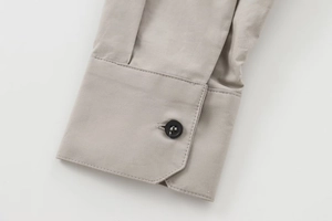 Detaillierte Nahaufnahme einer Hemdmanschette mit schwarzem Knopf und feinen Nähten