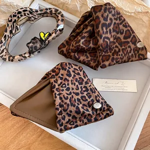 Leopard print hair claw set with plush fabric and heart charms on a white tray