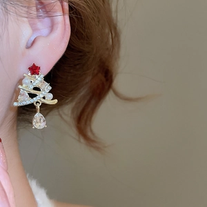 Detail of Christmas tree pearl earrings with sparkling crystals and red star on a model