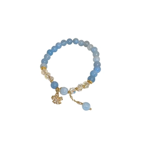 Bracelet extensible en cristal bleu vintage avec charm fleur dorée et détails en zircon